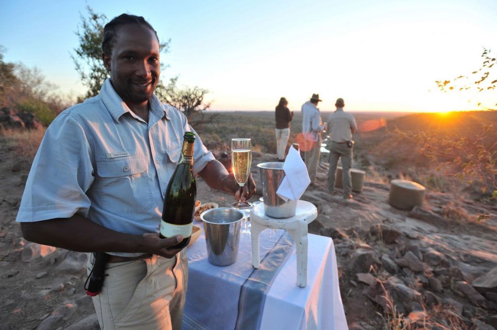 Touristes prenant un aperitif au coucher du soleil dans le parc national du Kruger, en Afrique du Sud.