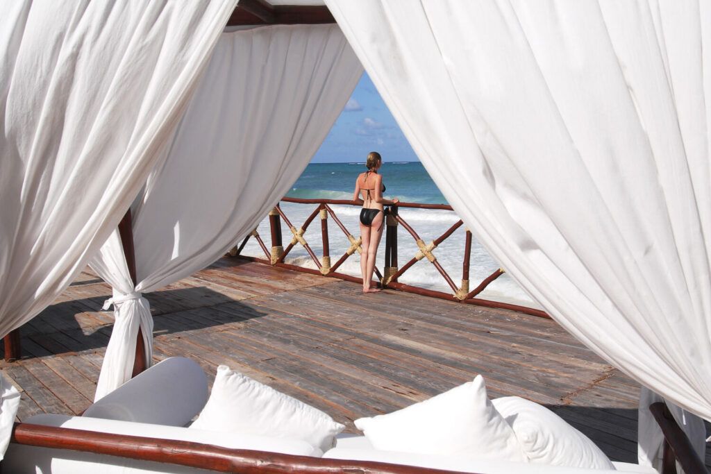 Jeune feme en maillot de bain sur la terrasse d'un hotel sur la plage de Diani au Kenya