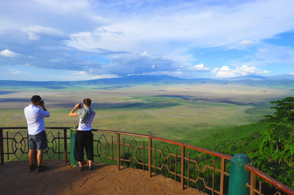 En Tanzanie, couple de touristes regardant le cratère du Ngorongoro depuis un point de vue en hauteur